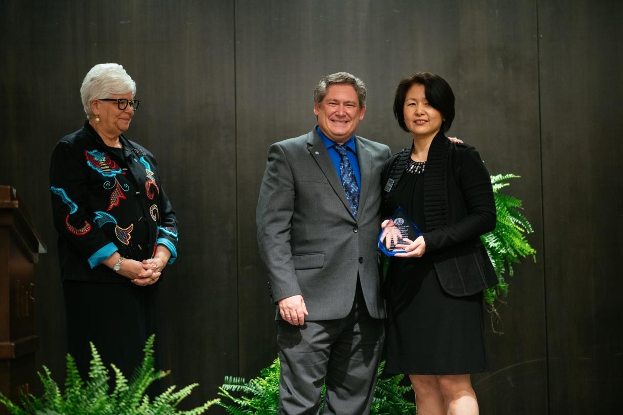 Picture of Dr. Myung-ah Lee with Provost Licari and President Curtis accepting the undergraduate Provost's Award